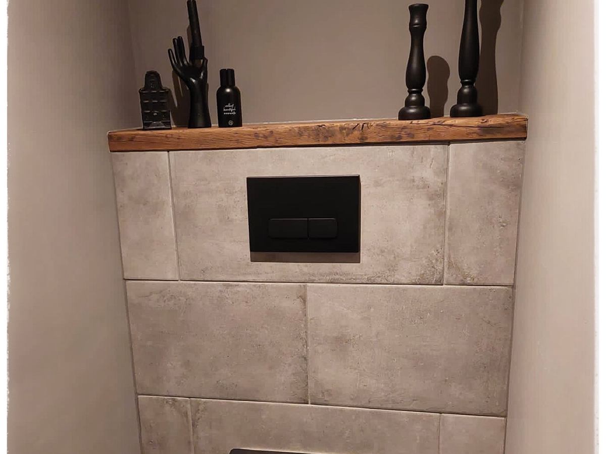 Oud eiken nisplank in een betegelde badkamer