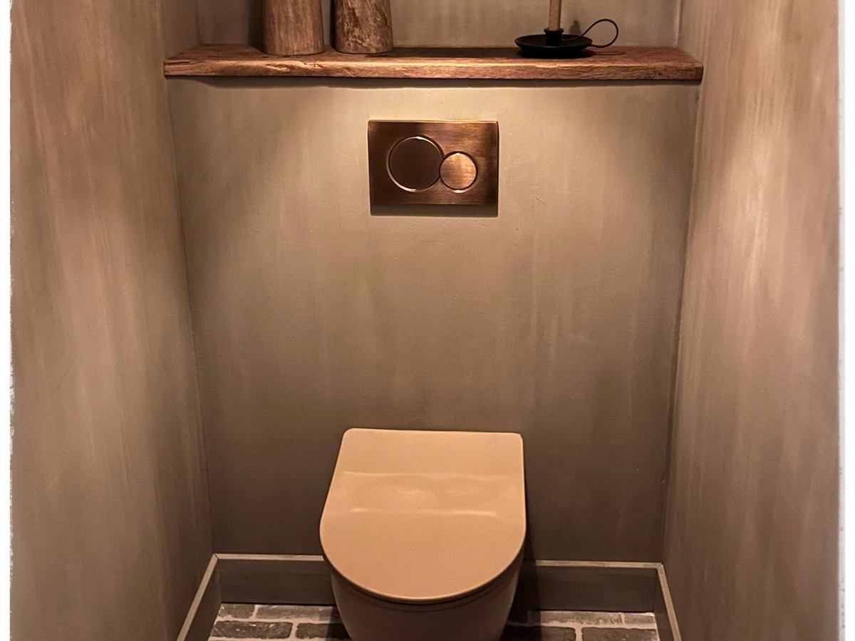 Oud eiken nisplank boven een toilet