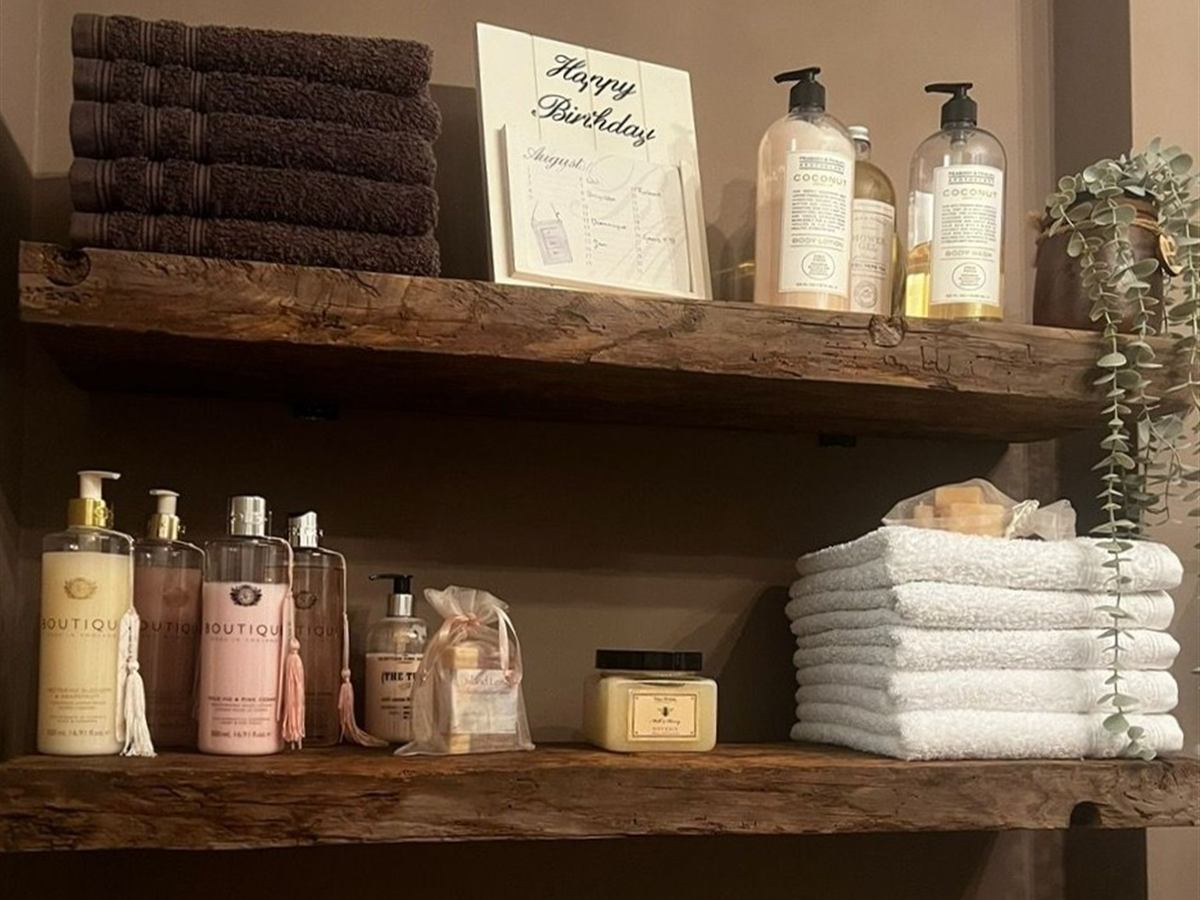 Oud eiken wandplank met handdoeken in een badkamer