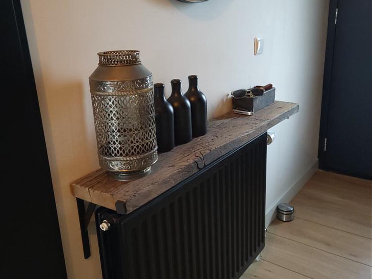 Oud eiken wandplank boven een radiator