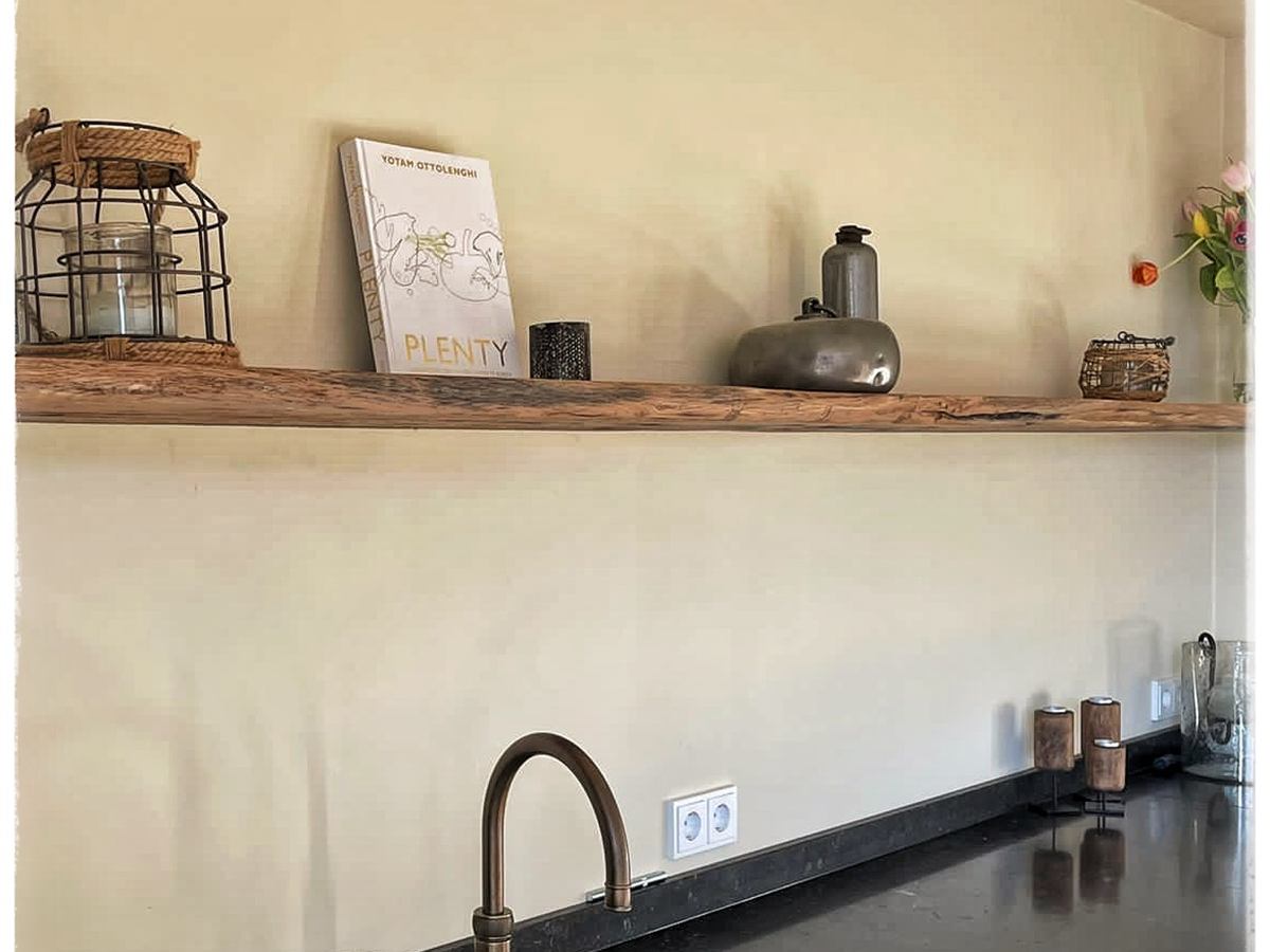 Oud eiken wandplank aan de achterwand van een keuken