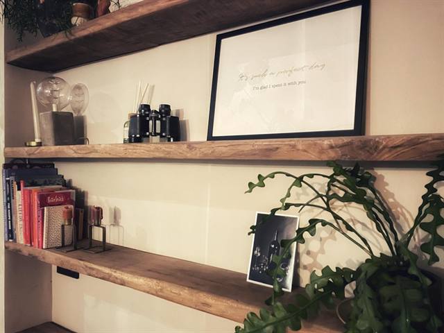 Oud eiken wandplanken met boeken en woonaccessoires bij een klant thuis
